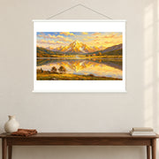 Alpine Village in Golden Reflection, shown as a complete bordered art print with white hanging rods above a console in a closer room view.