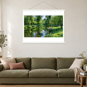 Willows Around the Garden Stream, shown as a complete bordered art print with white hanging rods above a sofa in a living room.
