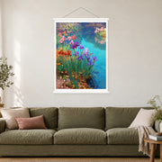 Purple Irises Along Blue Water, shown as a complete bordered art print with white hanging rods above a sofa in a living room.