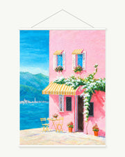 Pink House by the Sea art print with included white cylindrical hanging rods